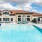 Apartments In Reno For Rent - Vida - Resort-Style Swimming Pool, Sundeck, Lounge Chairs, Plush Couches, And Resident Building In The Background