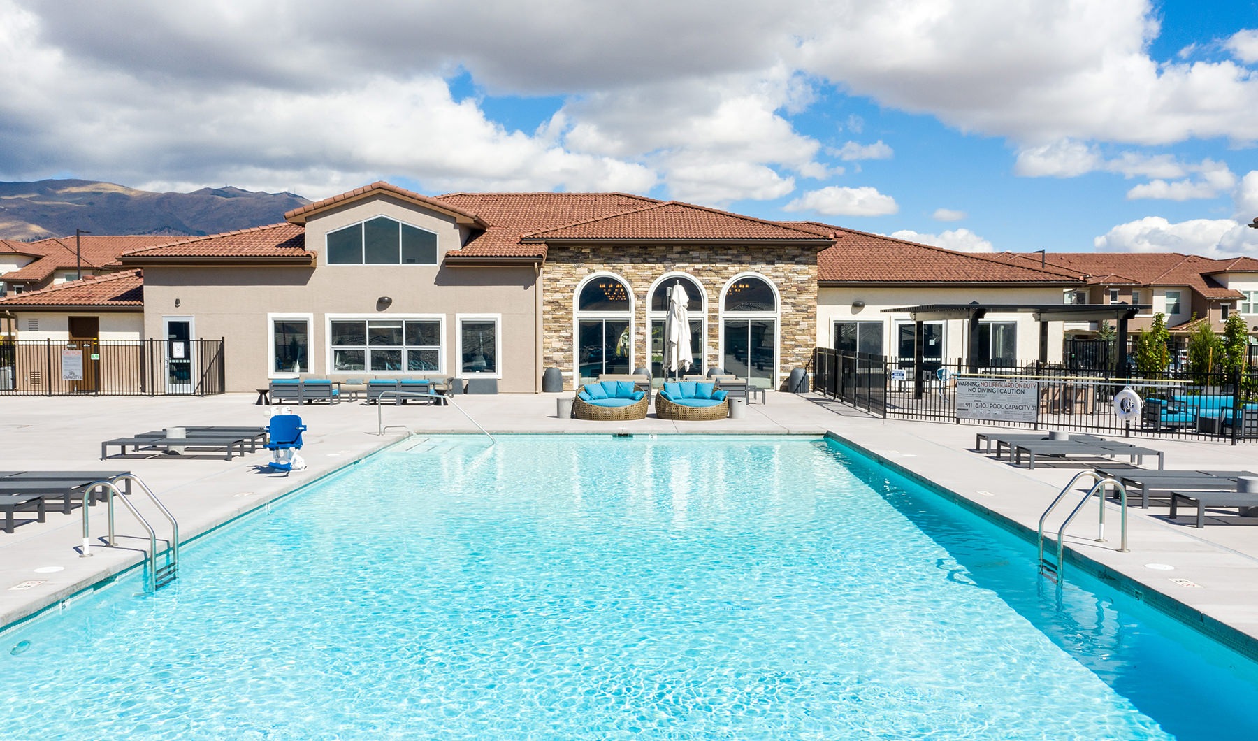 Large sparkling blue pool with sundeck and a large patio 