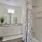 Dog Friendly apartments in Reno NV - Vida - White Bathroom with Full Shower and TUb, Built-In Shelving, Vanite with A Mirror and White Cabinetry, Grey Countertops, and a Rug